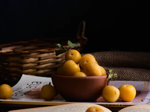 A rustic stoneware bowl filled with fresh fruit, highlighting the earthy texture
