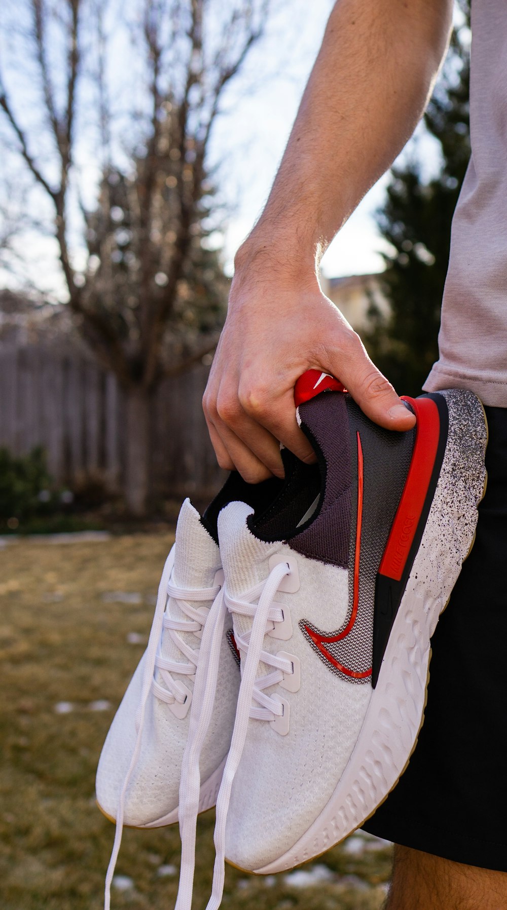 person holding white and black nike athletic shoe