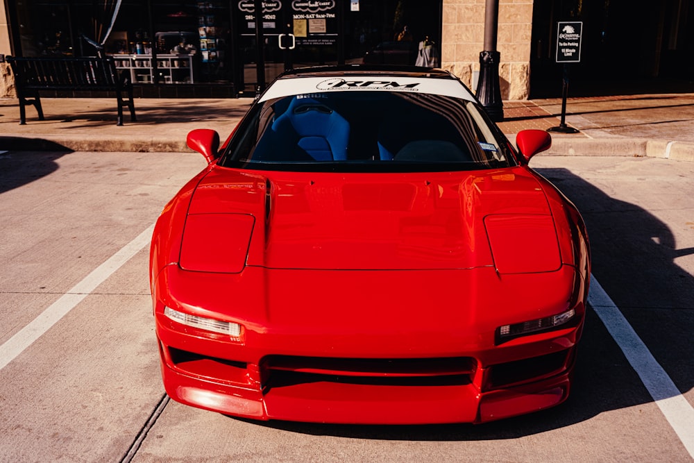 red chevrolet camaro parked on sidewalk during daytime