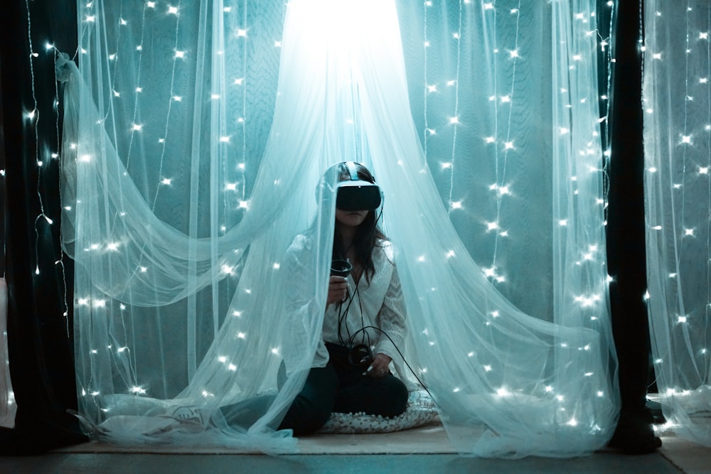 femme en robe noire et blanche assise sur le lit