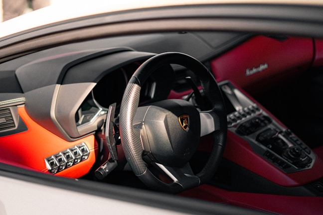 A sleek black and red sports steering wheel.