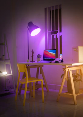 A sleek modern office desk with a laptop, smartphone, and a purple accent lamp symbolizing digital communication.