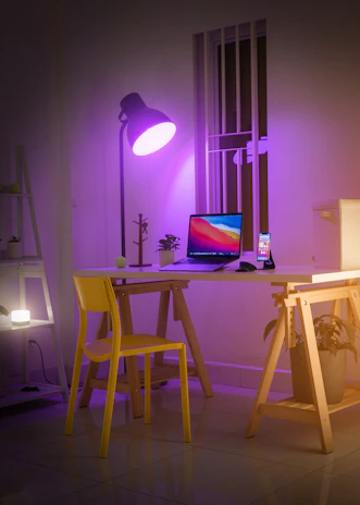 A sleek workspace with a laptop displaying the violeté logo, surrounded by soft purple lighting and minimalist decor.
