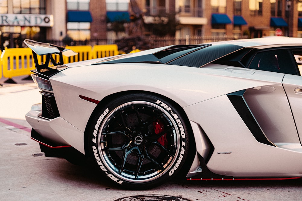 Weißer Lamborghini Aventador tagsüber auf grauem Bürgersteig geparkt