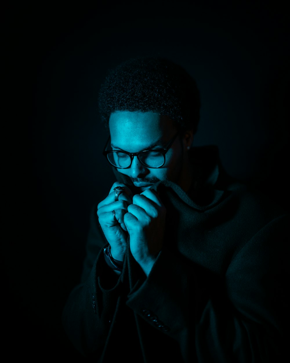 man in black hoodie covering his mouth