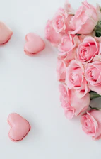 A delicate blush pink mini balloon bouquet arranged elegantly on a white marble surface.