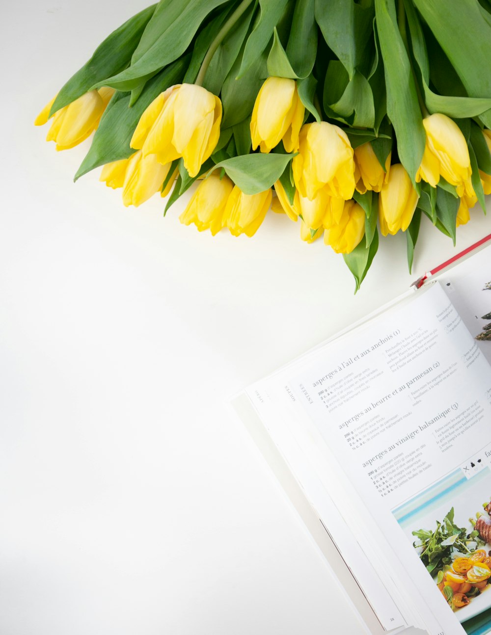 yellow tulips bouquet beside white printer paper