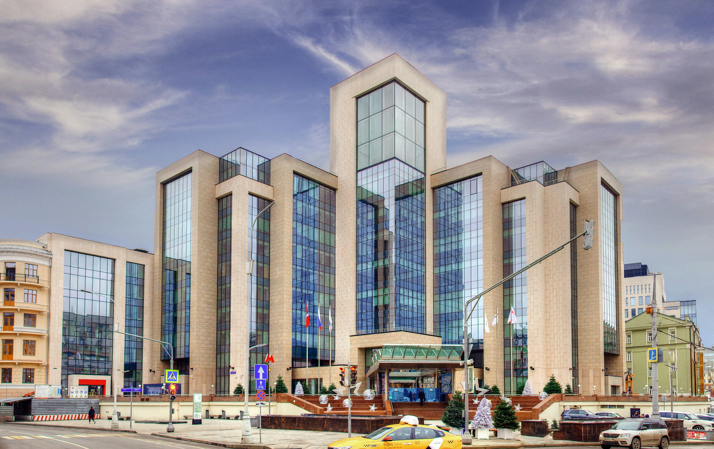 a yellow car is parked in front of a large building
