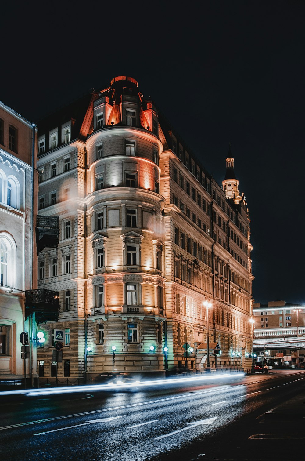 a large building lit up at night on a city street