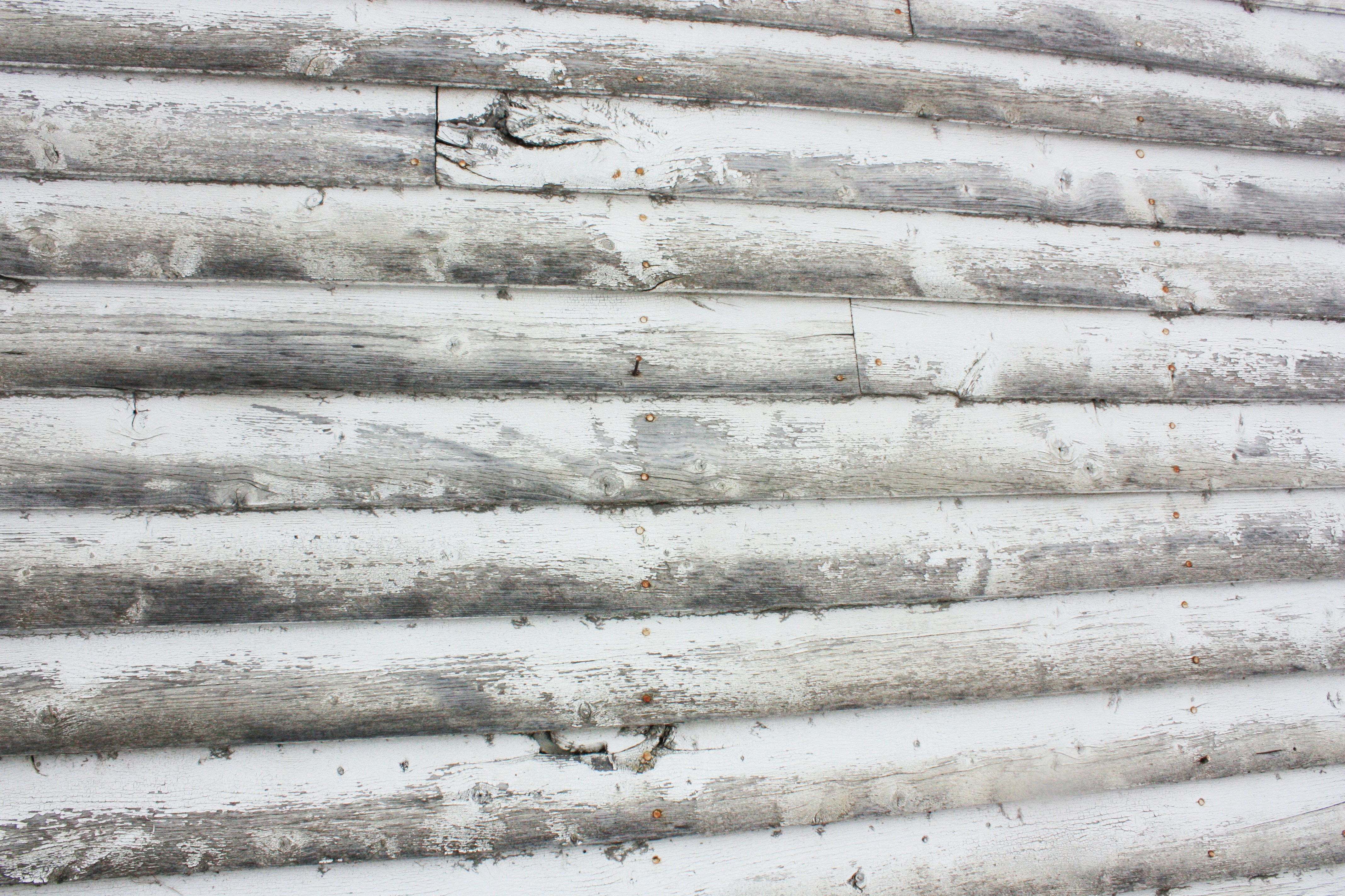 Two-story house exterior with peeling paint on white siding needing full repaint
