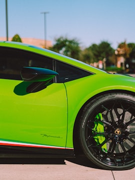Close-up of a freshly resprayed black car door with vibrant lime green accents.