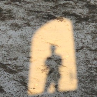 Abstract shadows cast on cracked concrete walls at night.