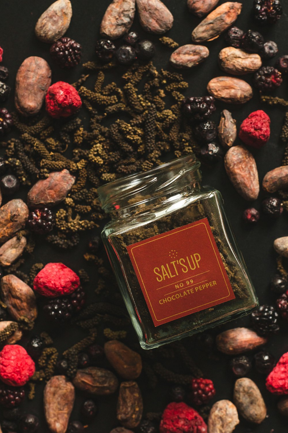 a jar of salts surrounded by nuts and berries