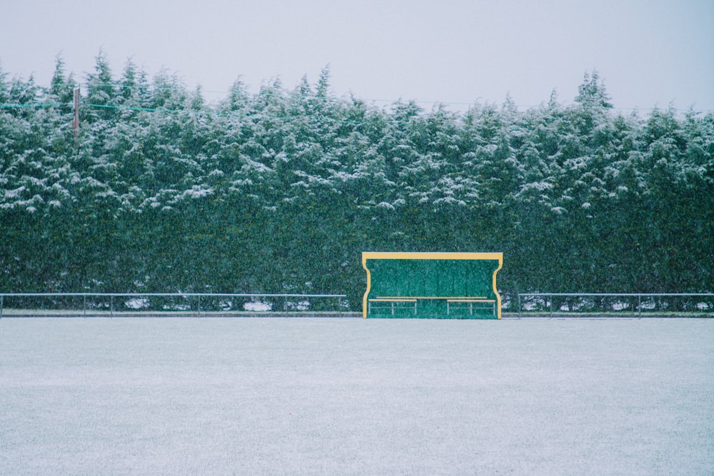 yellow metal bench on snow covered ground