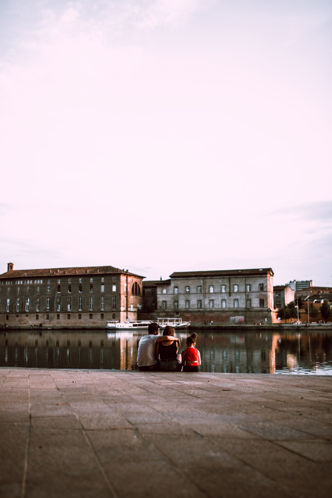 people walking on sidewalk near body of water during daytime