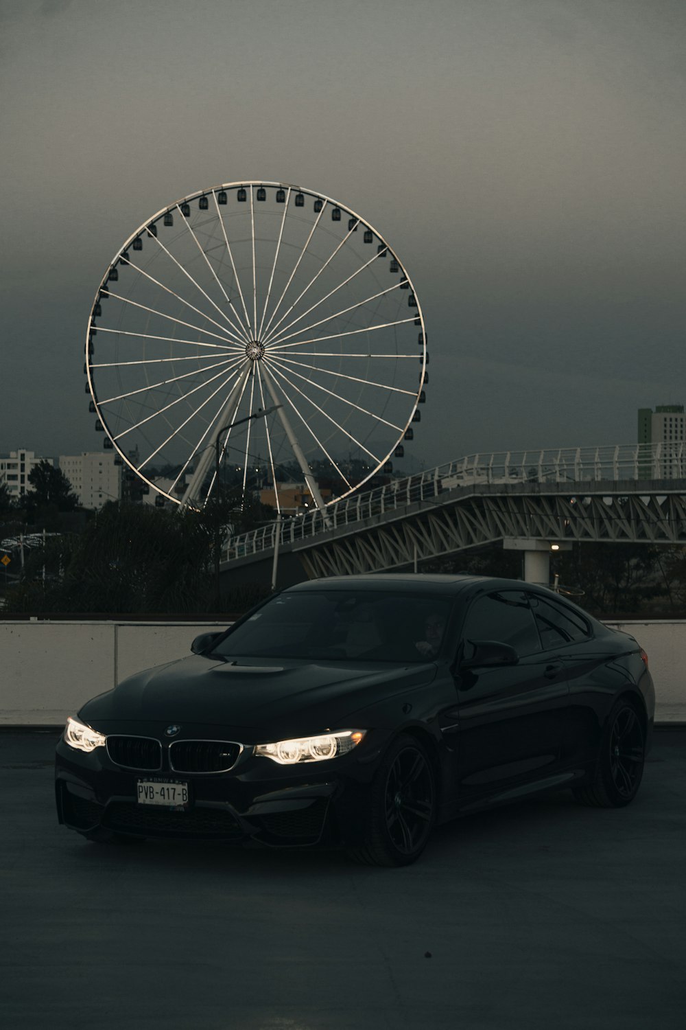 black car parked near ferris wheel during daytime