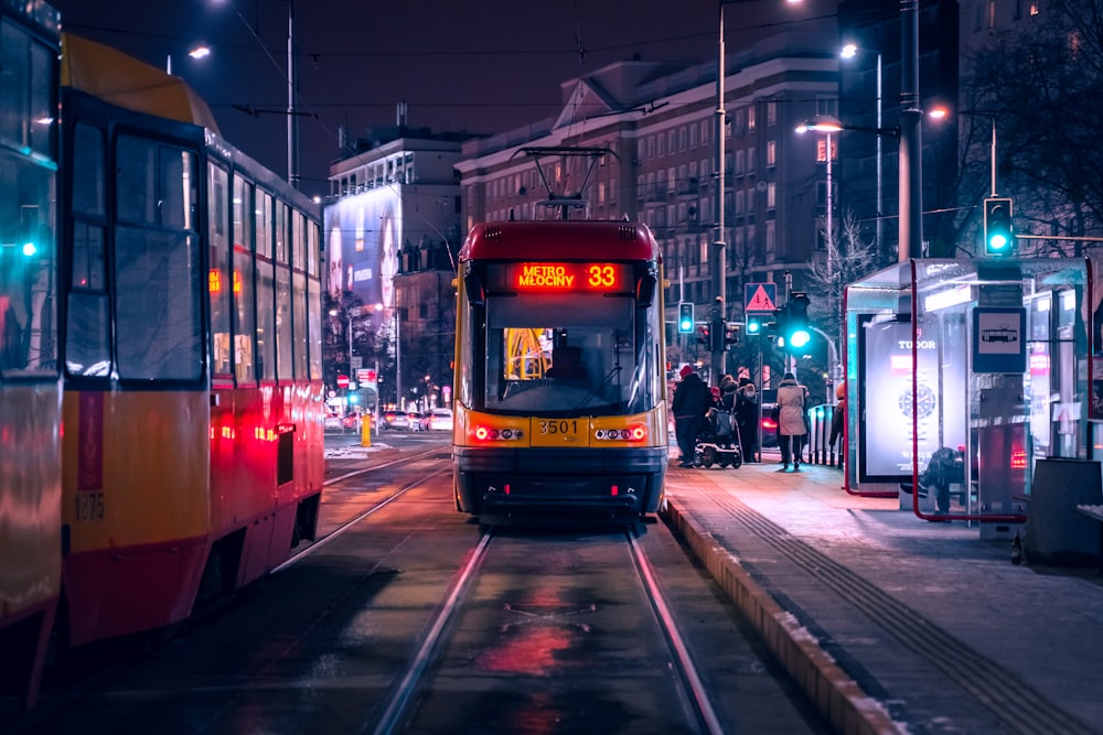 rote und schwarze Straßenbahn nachts auf der Straße