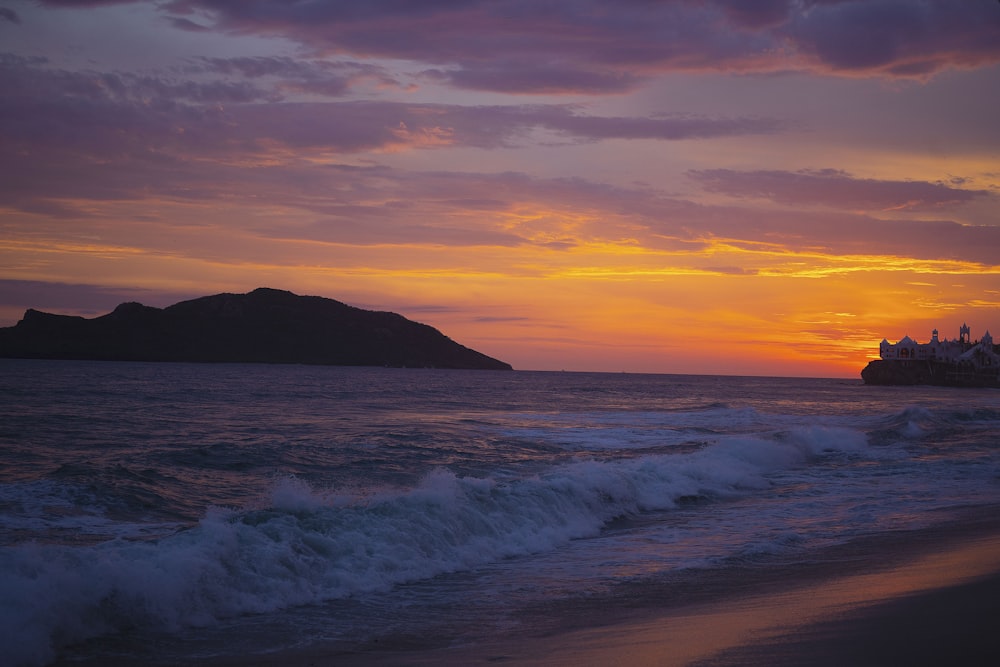 sea waves crashing on shore during sunset