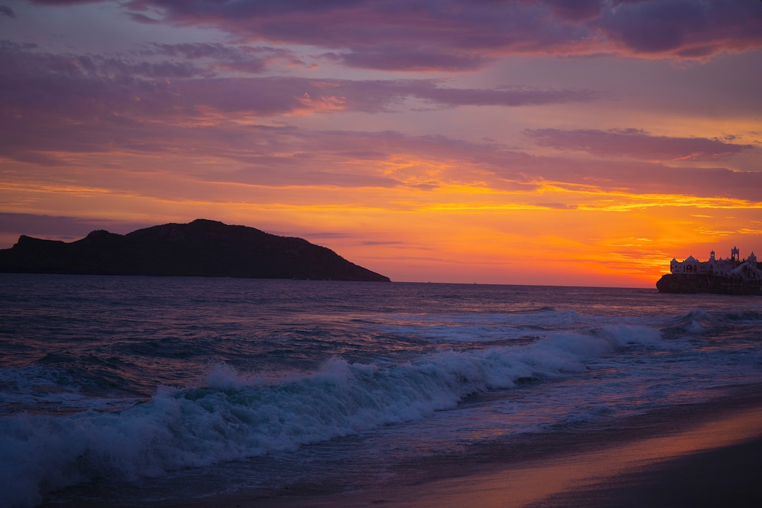 sea waves crashing on shore during sunset