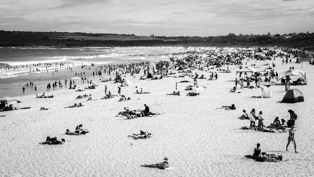 grayscale photo of people on beach