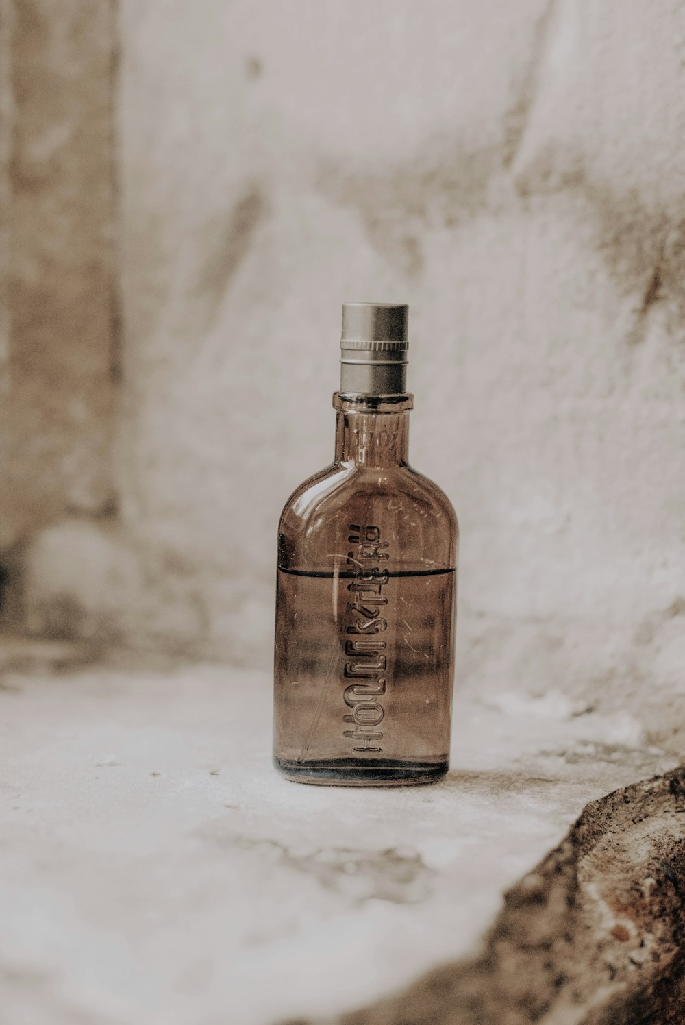 a bottle of water sitting on top of a rock