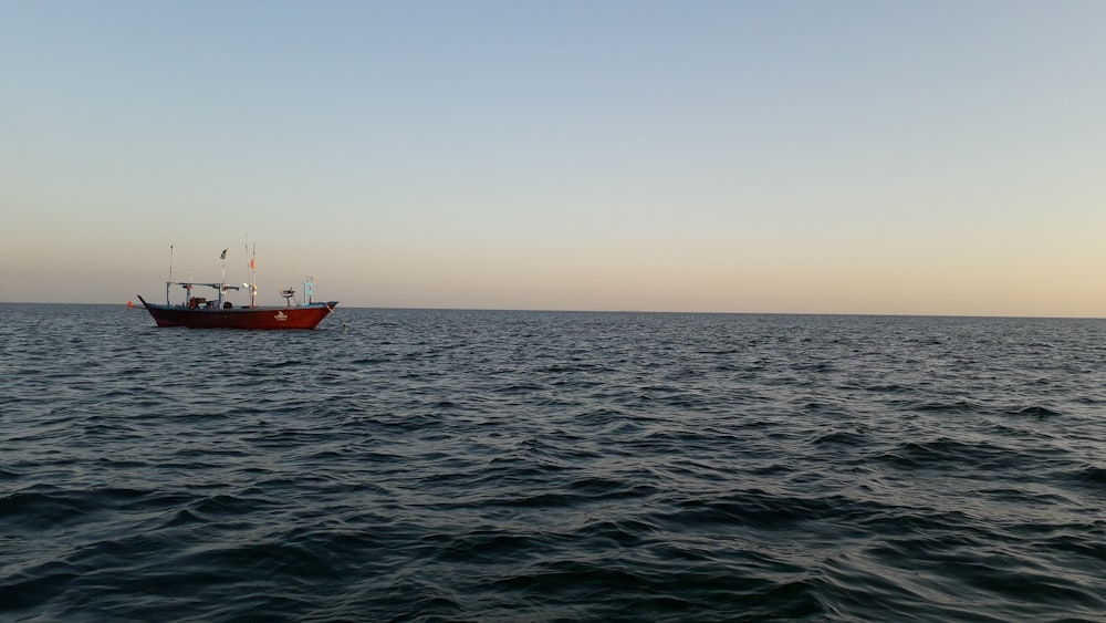 red and white boat on sea during daytime