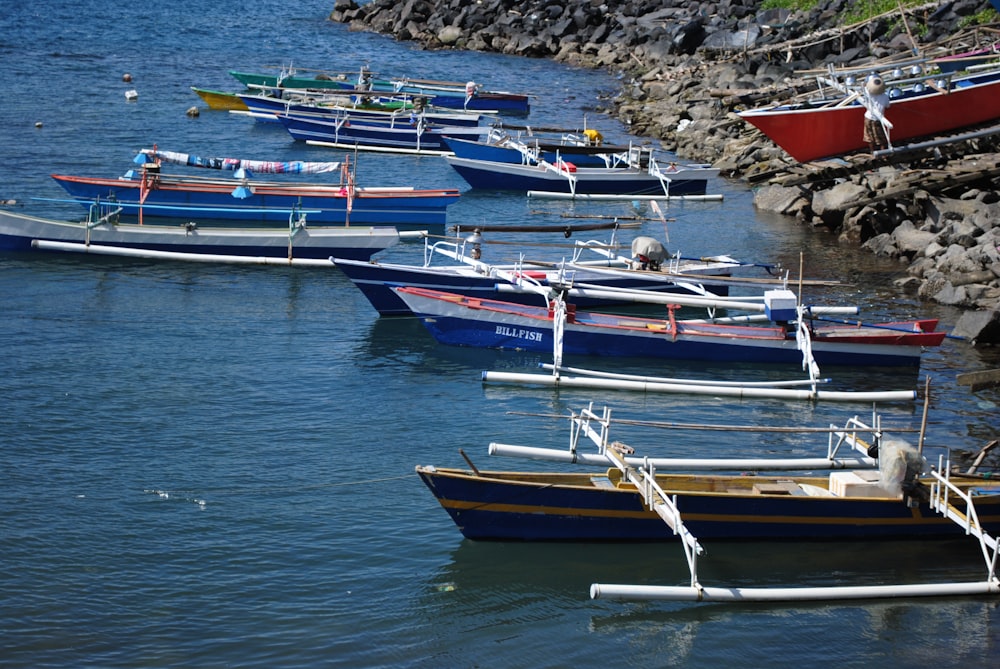 white and red boat on sea shore during daytime