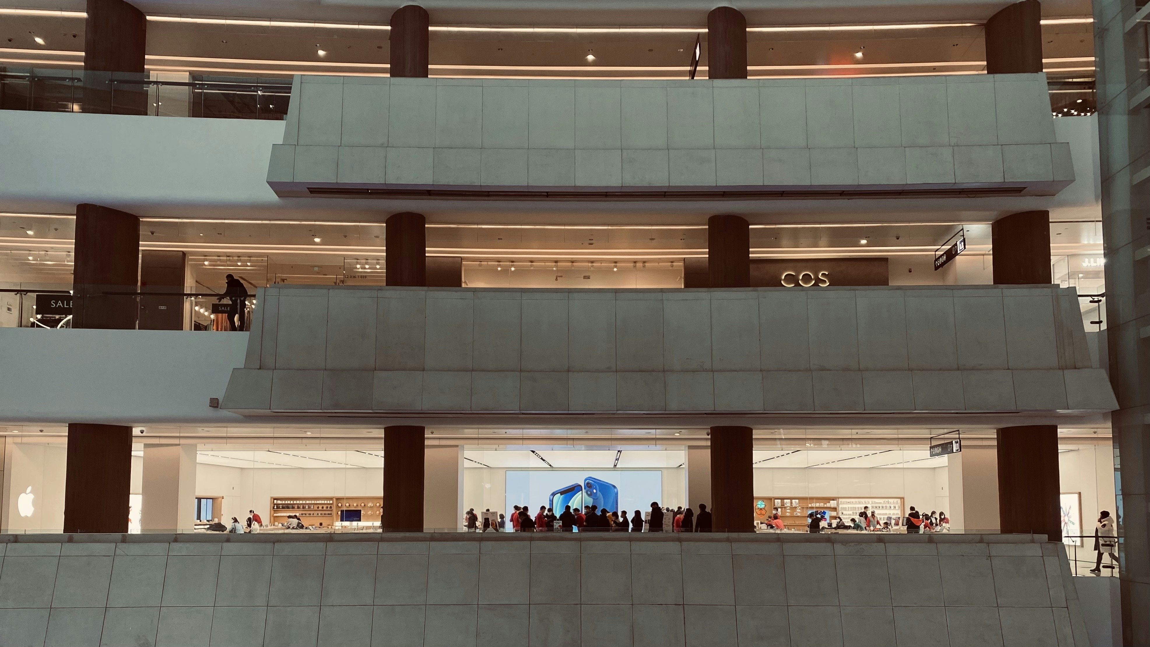 Busy modern retail shopping mall with multiple store fronts and shoppers