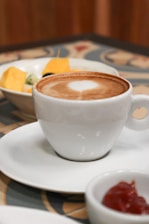 white ceramic cup with brown liquid inside
