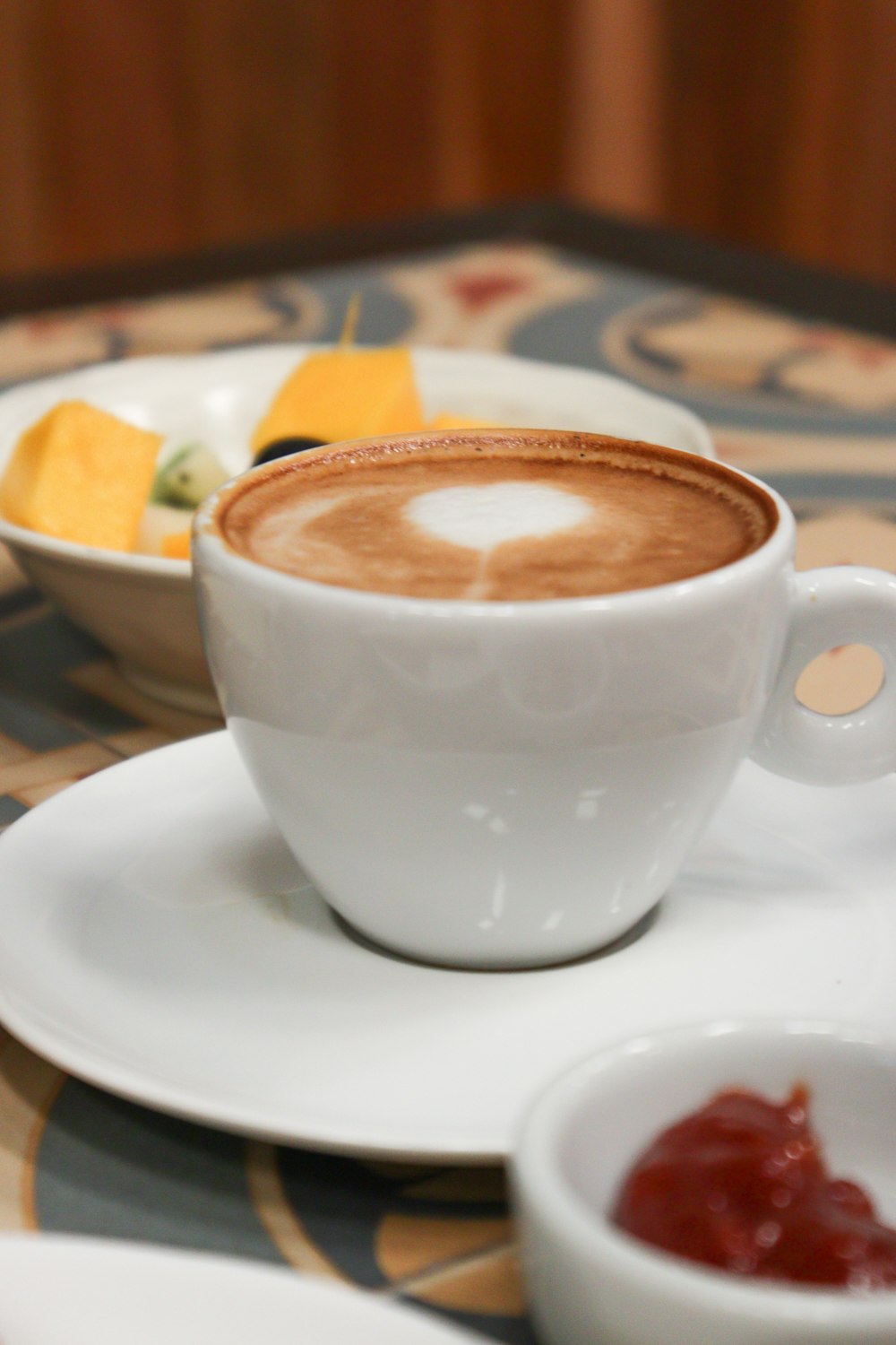 white ceramic cup with brown liquid inside