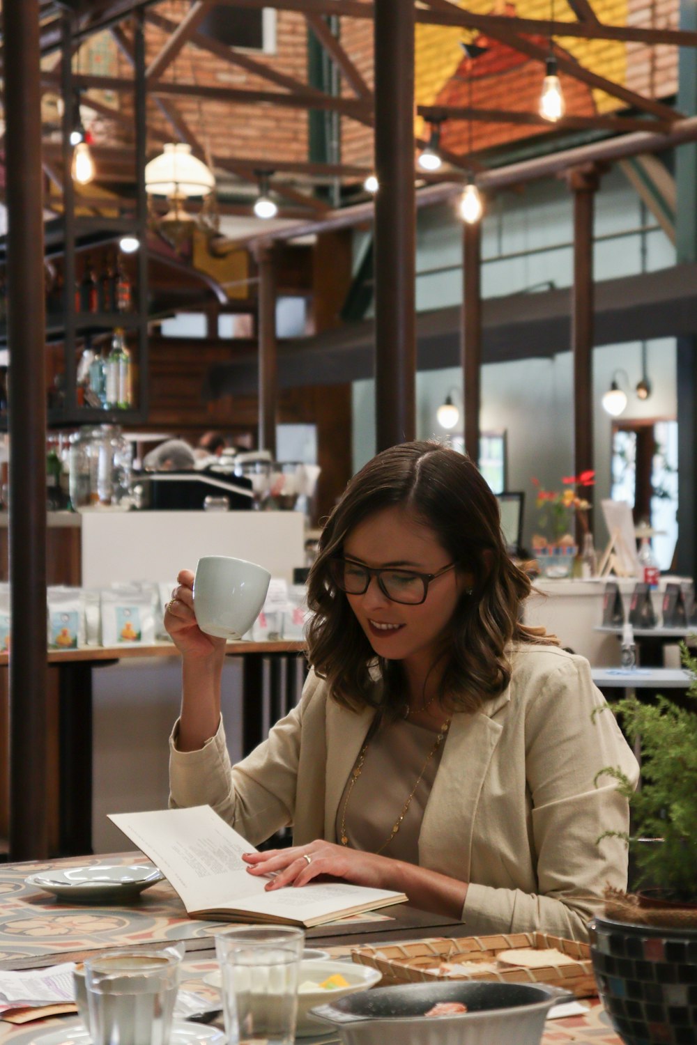 woman in white coat holding white ceramic mug