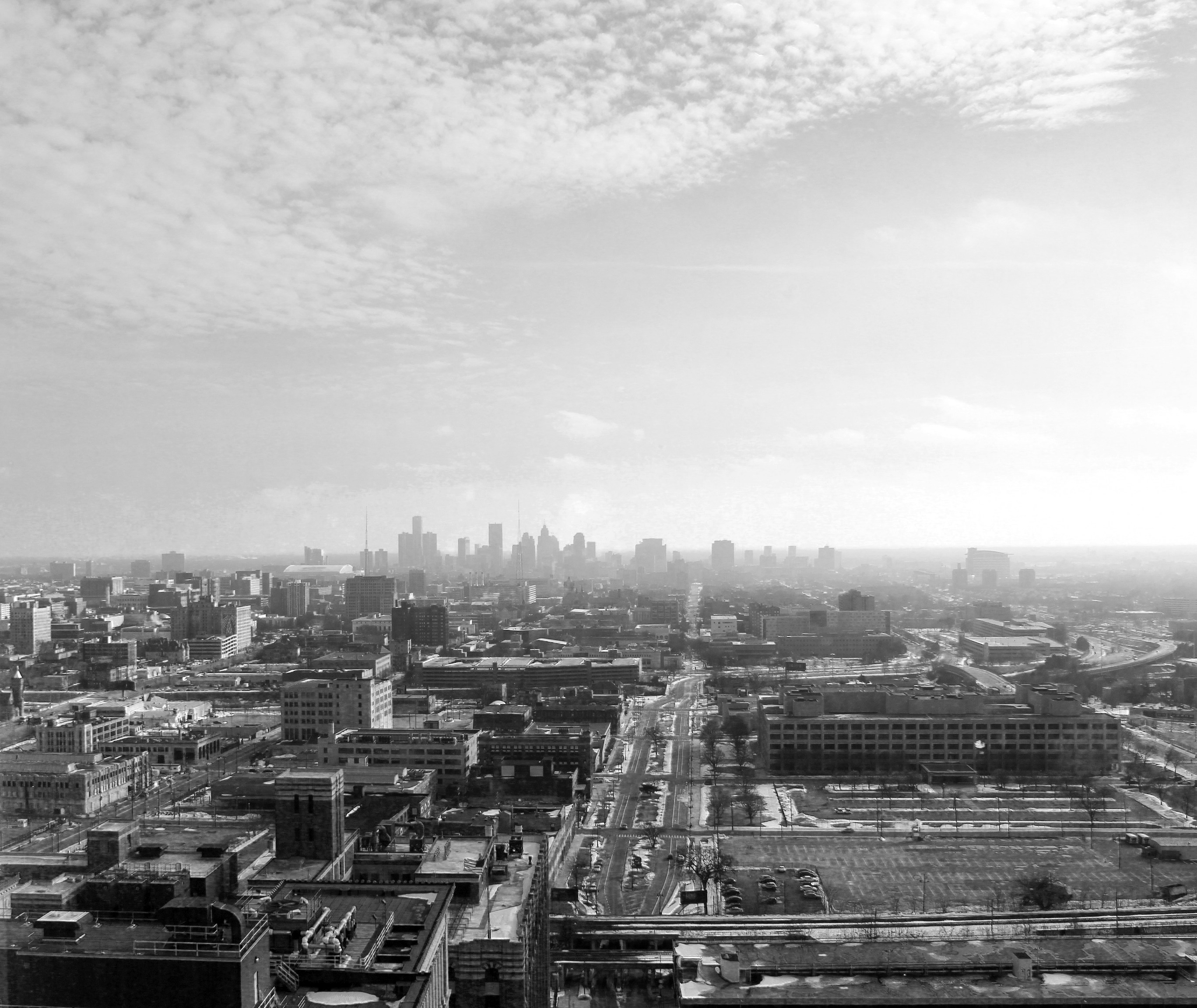 grayscale photo of city buildings, Detroit skyline from a window.