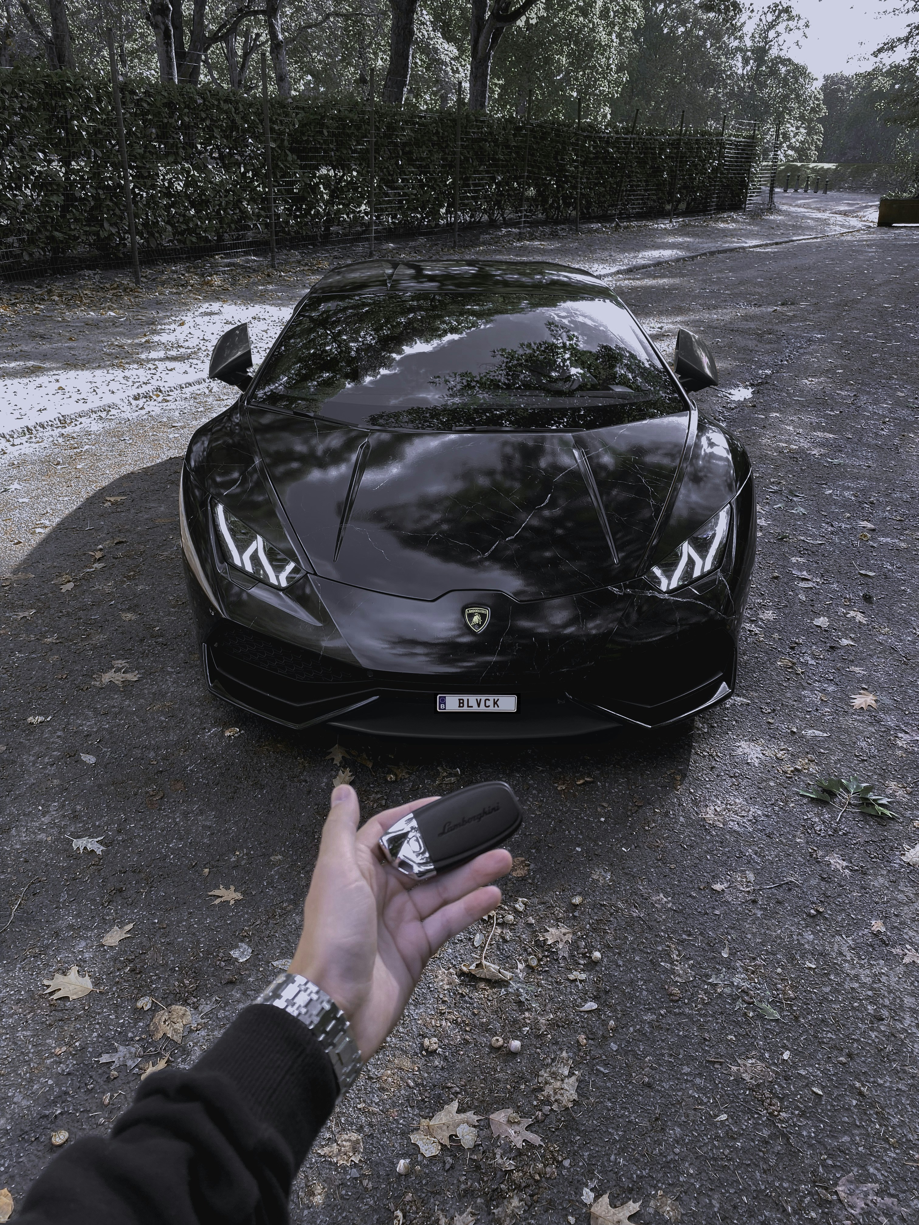 Persona che tiene la portiera nera dell'auto