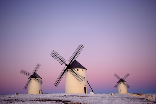 white and black windmill on white sand during daytime