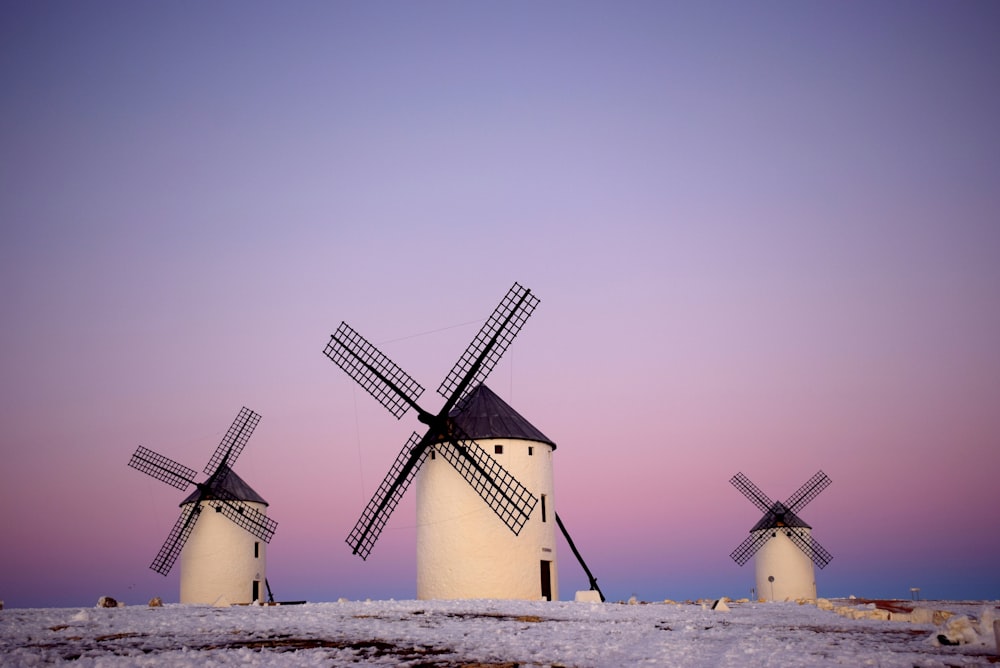 white and black windmill on white sand during daytime