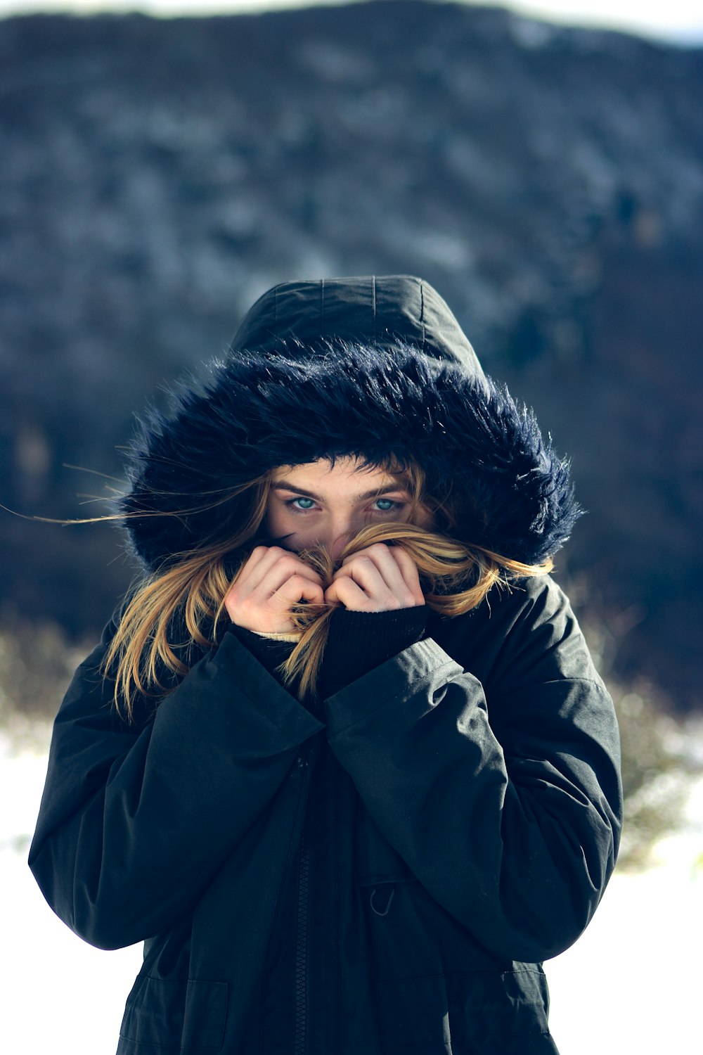 woman in black leather jacket covering her face with her hands