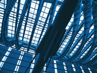 Dramatic architectural perspective of a high-tech warehouse ceiling with volumetric daylight and LED illumination.