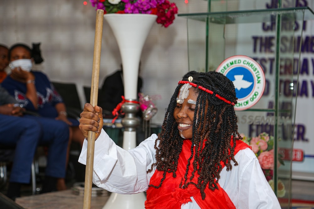 woman in red dress holding white stick