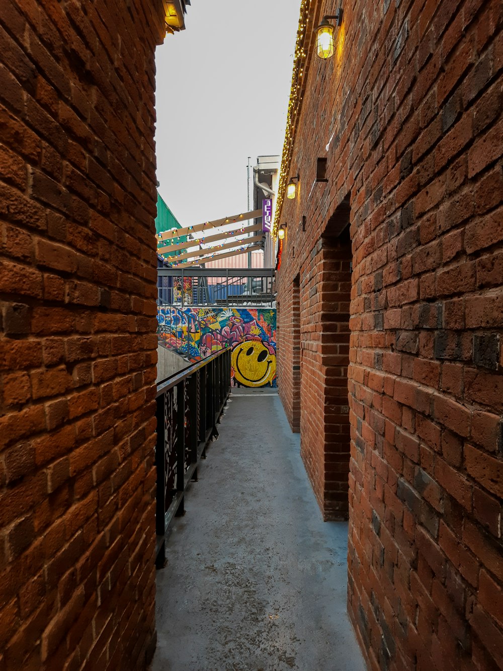 brown brick wall with yellow and black metal railings