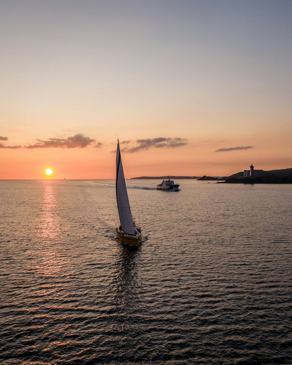 Voilier blanc sur la mer au coucher du soleil