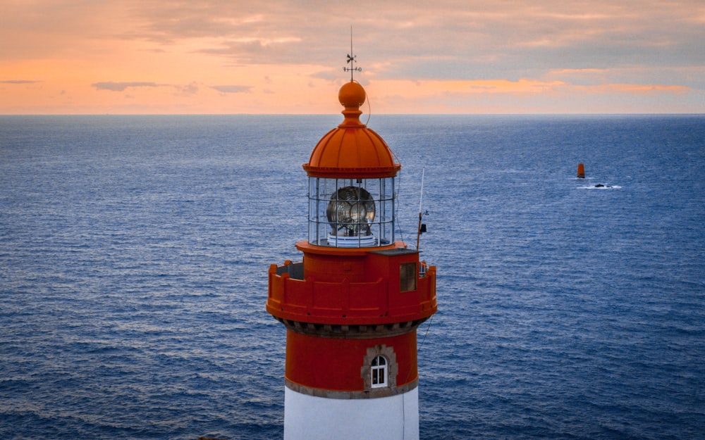 Faro rojo y blanco en el mar durante el día