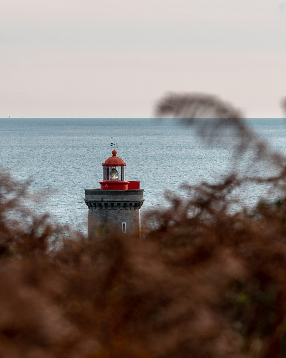 white and red lighthouse near body of water during daytime