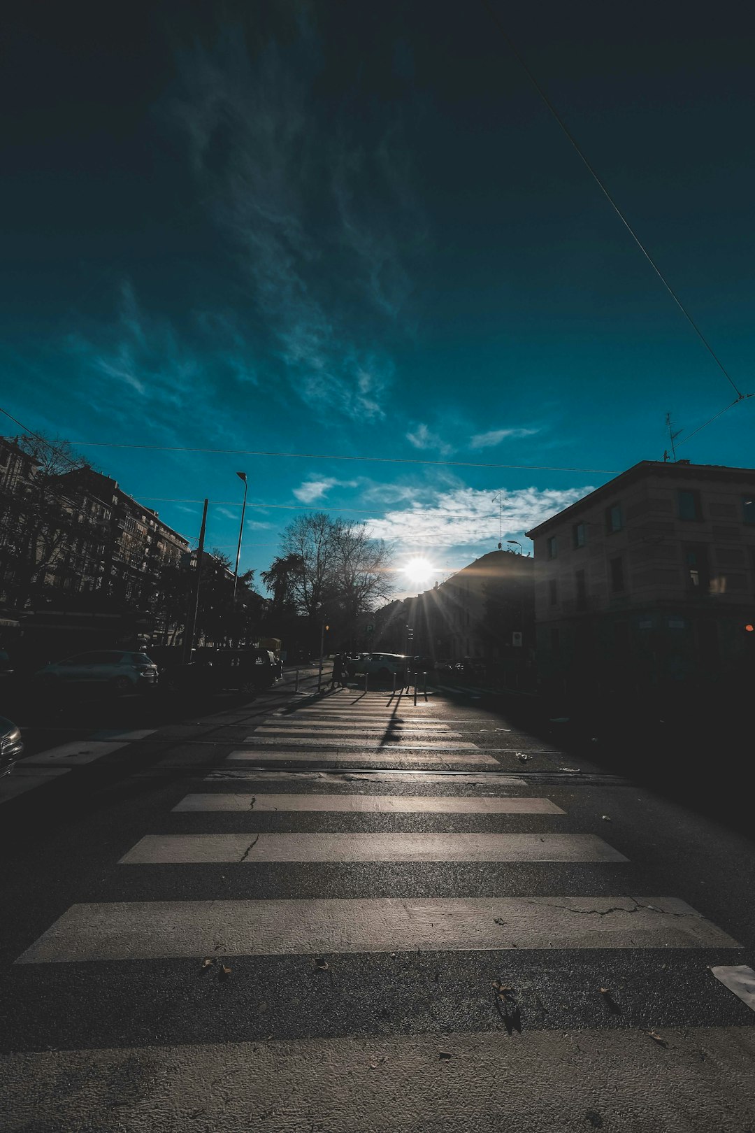 gray concrete road between houses under blue sky during daytime