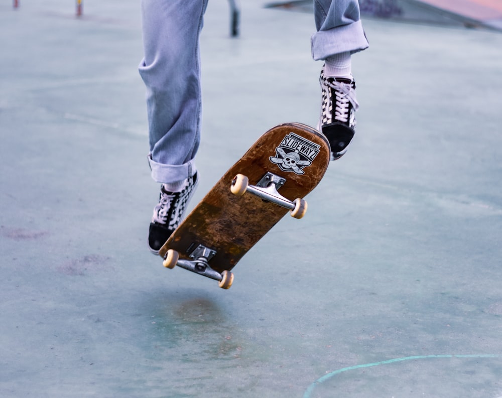 Eine Person, die auf einem Skateboard auf einer Betonoberfläche fährt