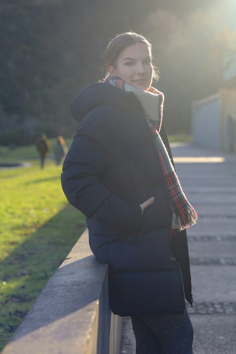 woman in black coat sitting on concrete bench during daytime