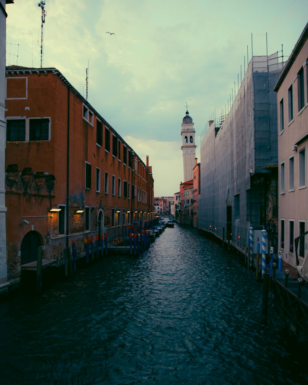 river between brown concrete buildings under white clouds during daytime