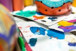 A close-up of colorful paint splatters on a palette.