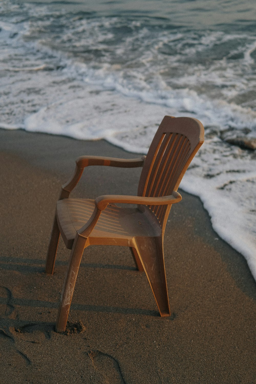 brown wooden armchair on beach shore during daytime