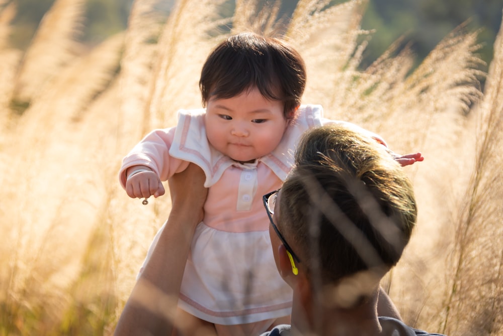 2 children standing on brown grass field during daytime