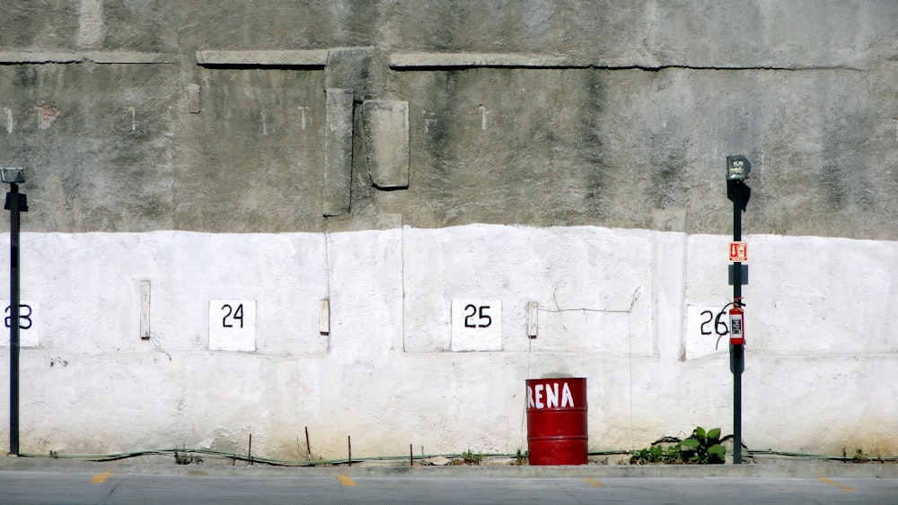 red and white no smoking sign on gray concrete wall